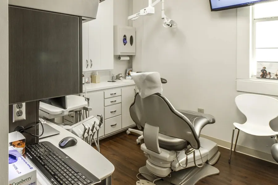 A treatment room at Uptown Dental: the dental chair, a computer and the cabinetry.
