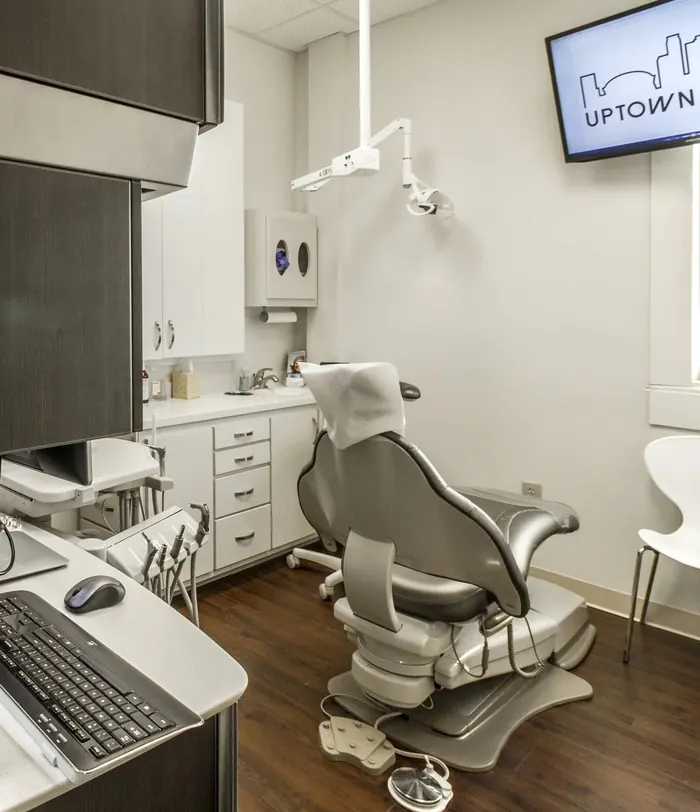 A treatment room at Uptown Dental, with the practice's skyline logo on the screen.